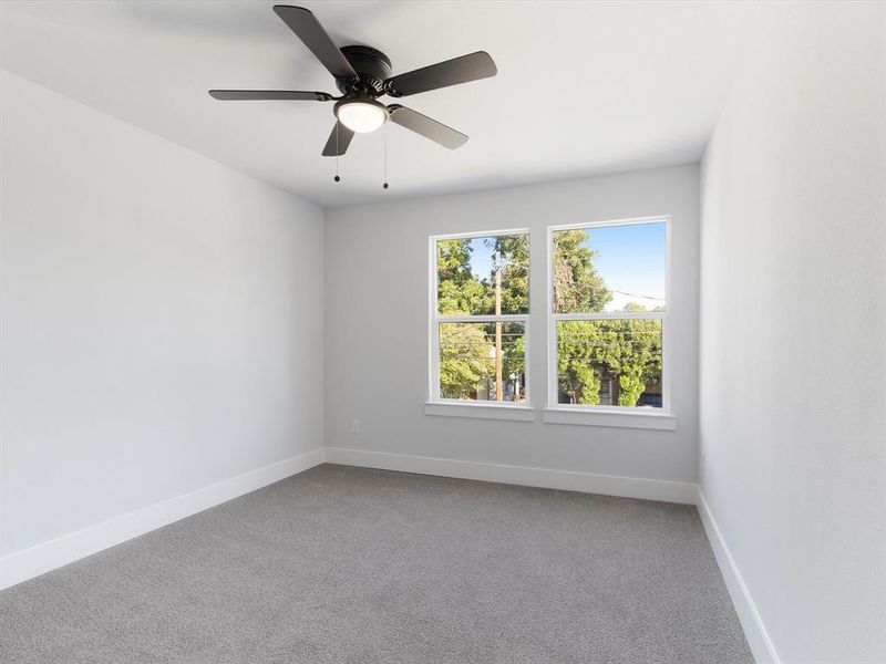 Carpeted empty room featuring ceiling fan