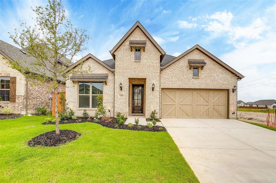 View of front of home featuring a garage and a front yard