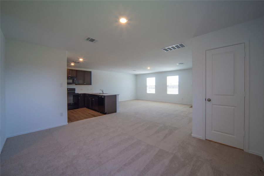 Unfurnished living room featuring light colored carpet and recessed lighting