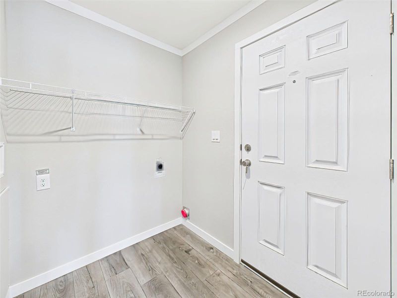 Laundry Room / Mudroom Entry – A bright and functional space with washer/dryer hookups, a wall-mounted shelf, and direct access to the exterior door.