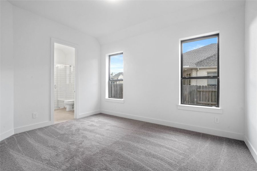 This guest suite, which offers a bright layout with neutral finishes and natural light. Featuring plush carpeting, large windows, and an en-suite secondary bathroom.