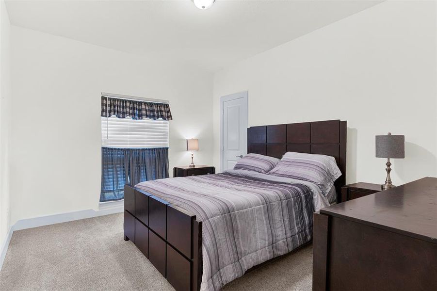 Bedroom with light colored carpet and baseboards Bedroom with light colored carpet and baseboards