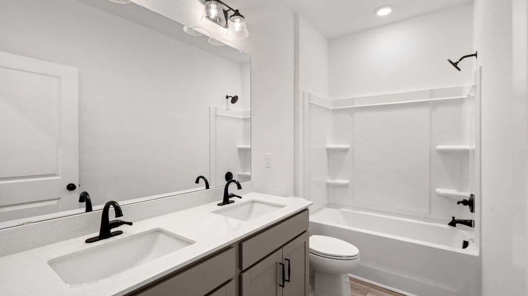 The Easton plan’s secondary bathroom includes a dual-sink vanity and a tub-shower combination.
