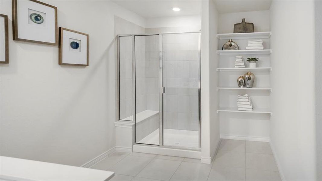 Glass-enclosed shower with a built-in bench and vertical tile surround