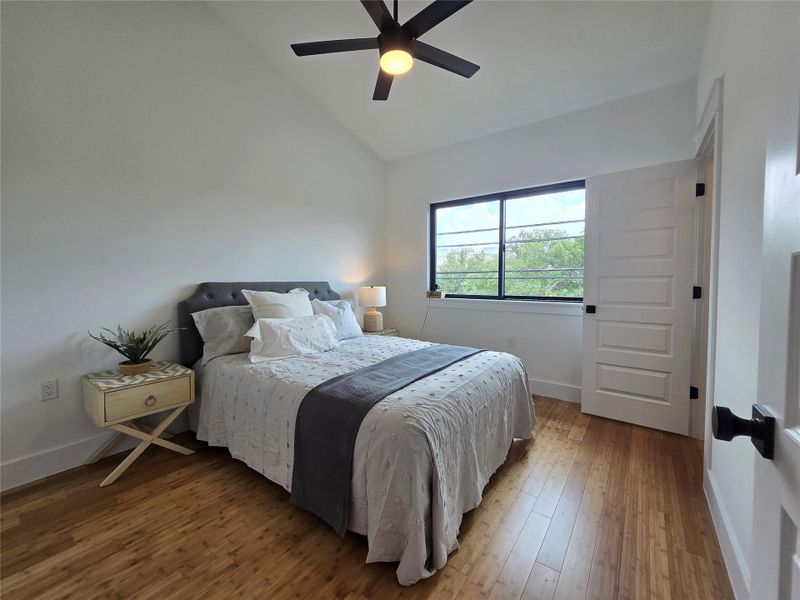 Bedroom featuring light wood-style floors, vaulted ceiling, and ceiling fan