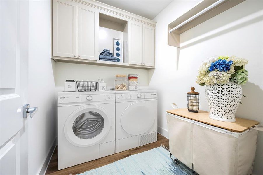 Large walk-in laundry room equipped with built-in storage cabinets and open middle shelf + built-in hanging rod. Located just off master hall-way and mudroom. Washer/Dryer virtually staged.