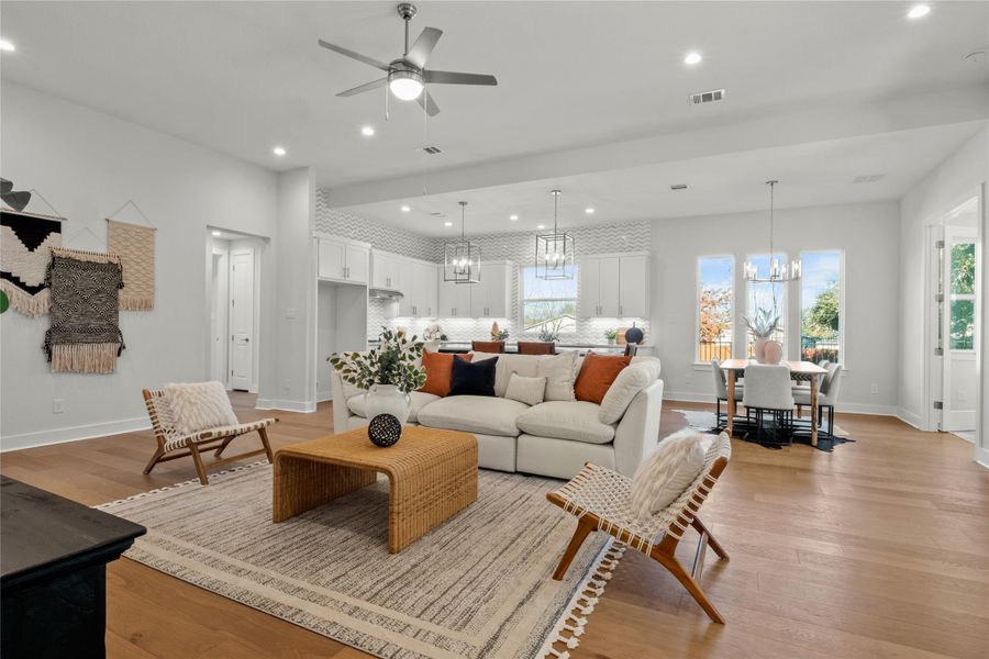 Living room featuring light wood finished floors, a chandelier, recessed lighting, and a ceiling fan Living room featuring light wood finished floors, a chandelier, recessed lighting, and a ceiling fan