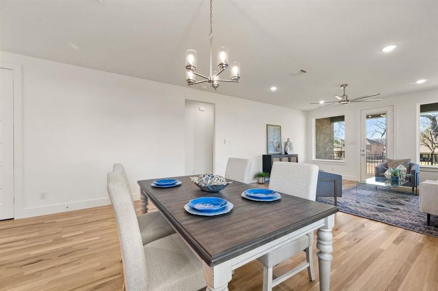 Dining room featuring ceiling fan, light wood-style flooring, and hanging lights