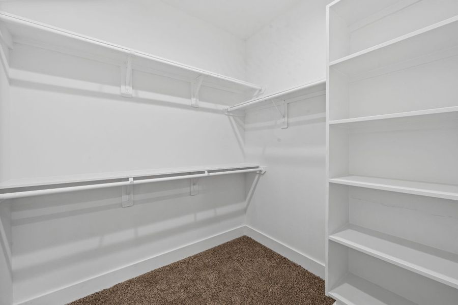 Spacious walk-in closet with ample shelving and hanging space, perfect for organized storage.
