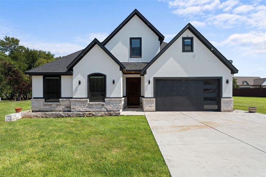 View of front of house with stucco siding, concrete driveway, and stone siding View of front of house with stucco siding, concrete driveway, and stone siding