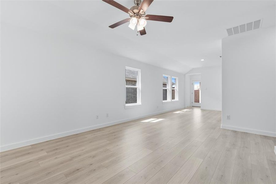Unfurnished living room with lofted ceiling, light wood-style floors, ceiling fan, and recessed lighting Unfurnished living room with lofted ceiling, light wood-style floors, ceiling fan, and recessed lighting