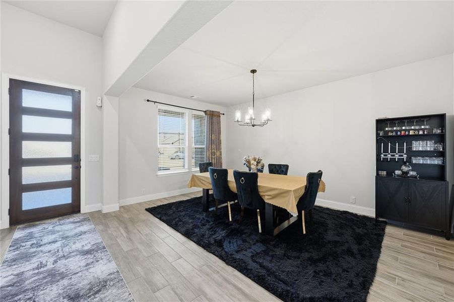 Dining room featuring wood tiled floors and a chandelier