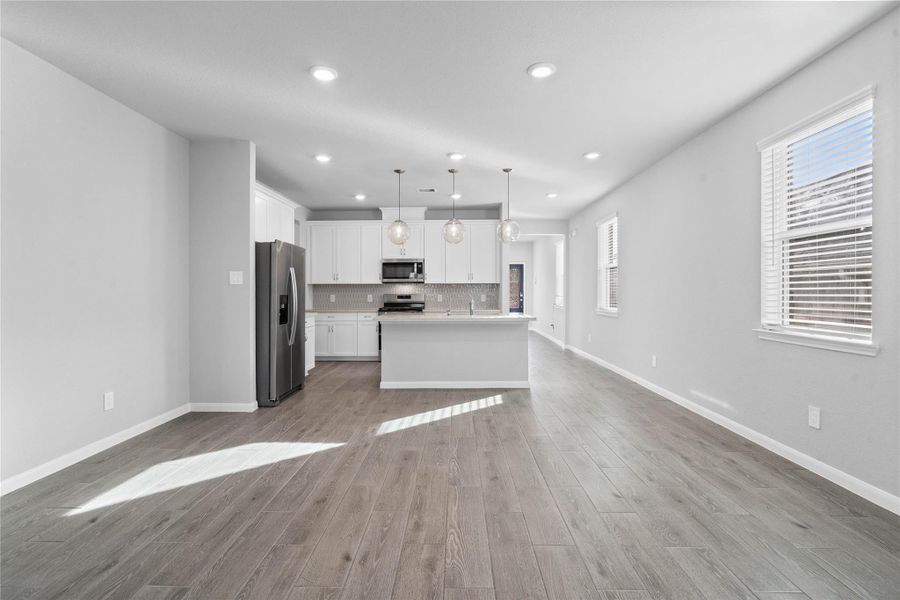 Enjoy meals in this sun-drenched space, featuring durable LVP flooring, abundant natural light from the large windows (fitted with blinds), and recessed lighting.