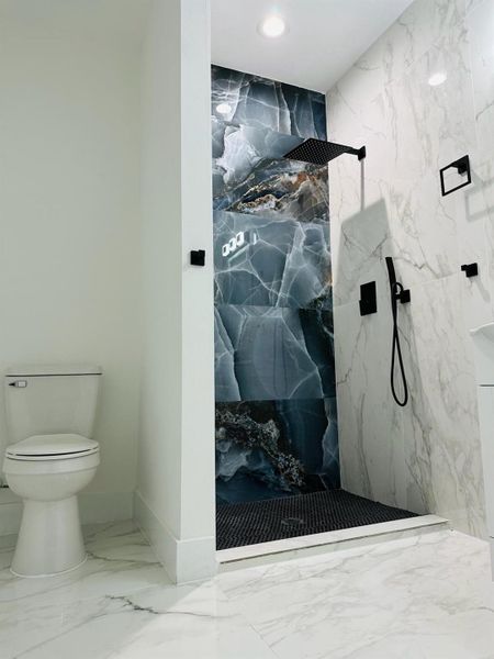 Full bath with light marble finish flooring, a marble finish shower, and recessed lighting Full bath with light marble finish flooring, a marble finish shower, and recessed lighting