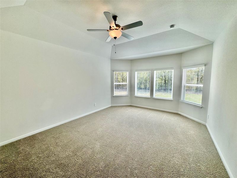 Unfurnished room with carpet, a textured ceiling, a ceiling fan, and vaulted ceiling Unfurnished room with carpet, a textured ceiling, a ceiling fan, and vaulted ceiling