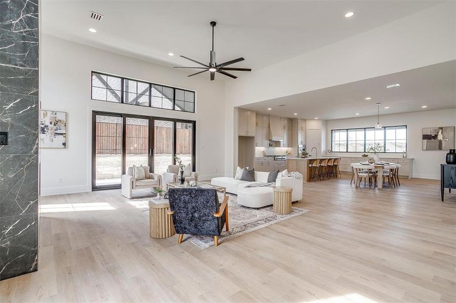 Living room featuring a ceiling fan, recessed lighting, light wood-style floors, and baseboards