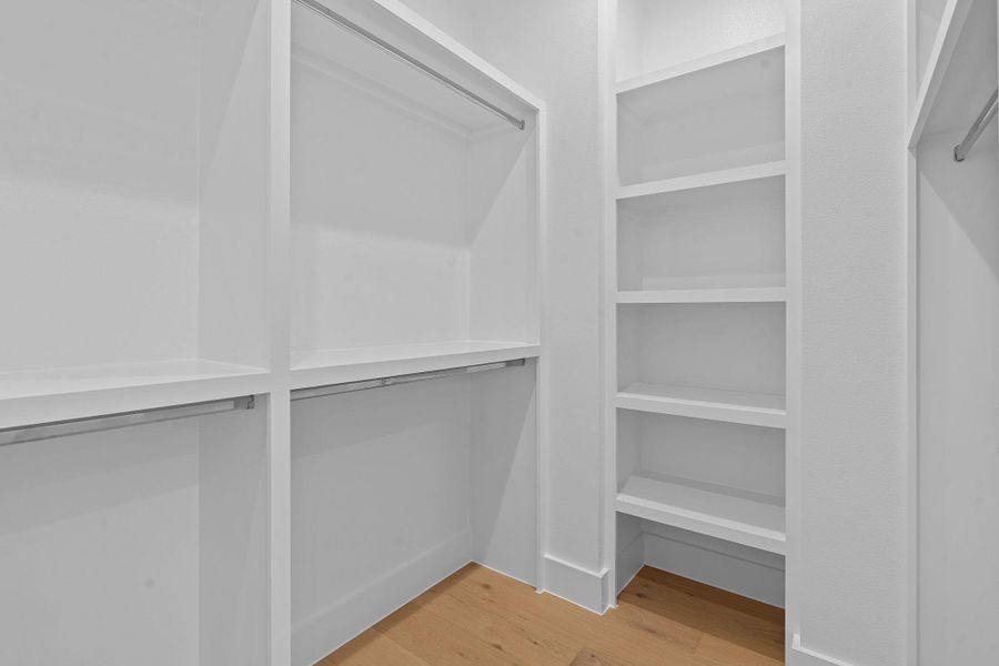 Walk in closet with light wood-style floors Walk in closet with light wood-style floors