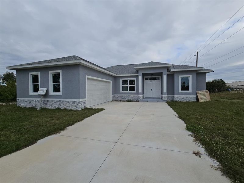 Front exterior of a new home in , Port Charlotte, FL, highlighting curb appeal (Image 1).