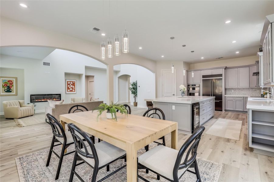 Dining area with light wood-type flooring, sink, and beverage cooler