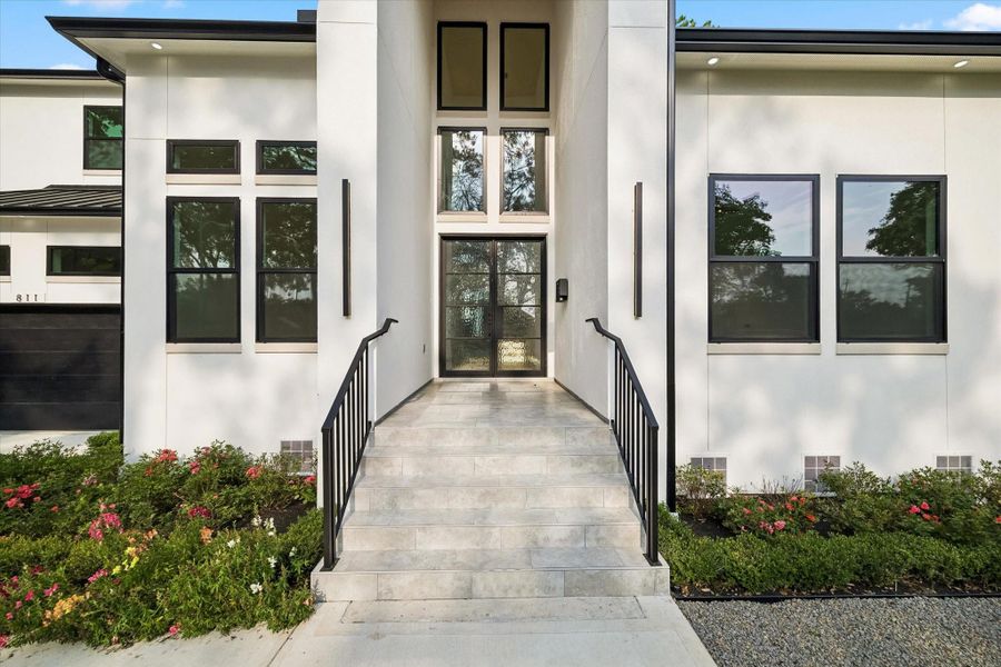 Clean design in the high end black trim windows and double and glass iron entry doors. Accent soffit lighting. Extensive landscaping includes pebble stone and steel perimeter edging. Full gutters and French drains.