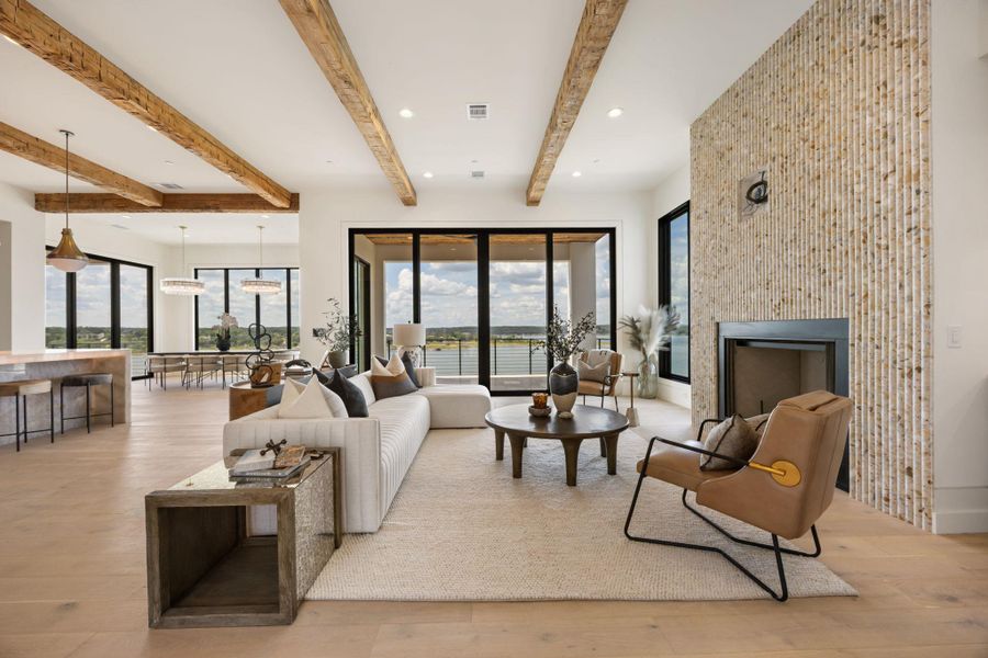 An airy living room offers open-concept living and breathtaking water views through expansive glass doors. An airy living room offers open-concept living and breathtaking water views through expansive glass doors.
