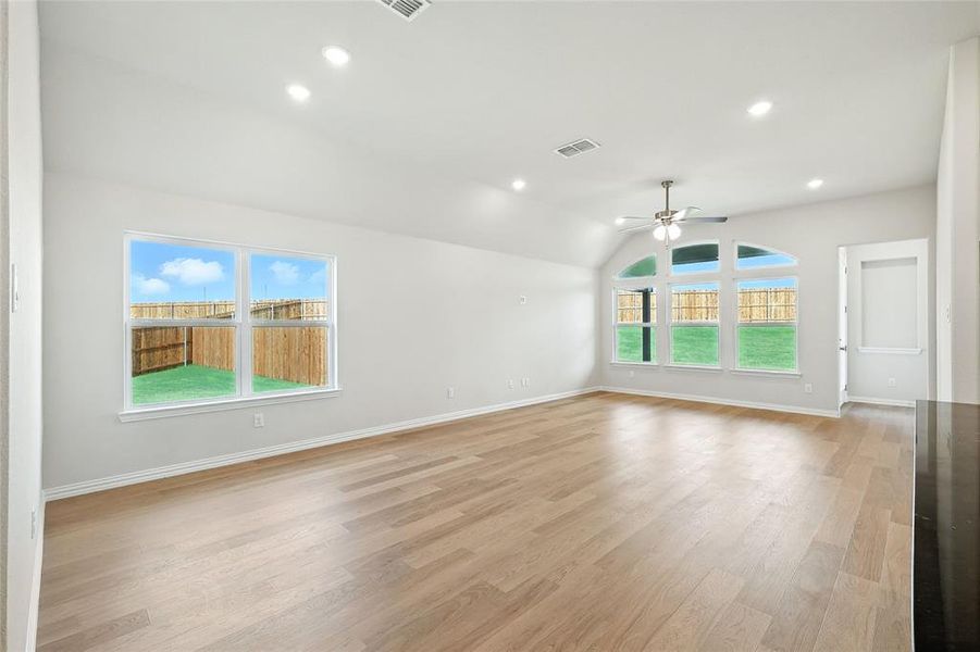 Empty room with plenty of natural light, ceiling fan, vaulted ceiling, light wood-type flooring, and recessed lighting Empty room with plenty of natural light, ceiling fan, vaulted ceiling, light wood-type flooring, and recessed lighting