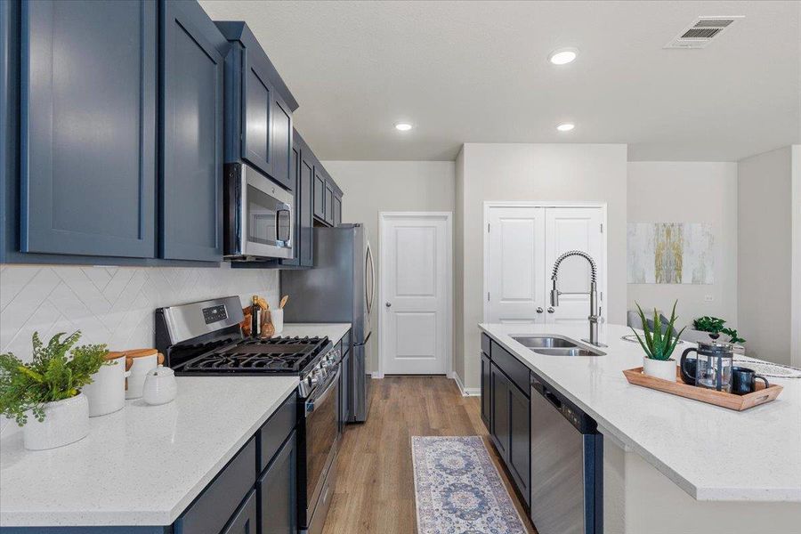 The kitchen is adorned with painted cabinetry, quartz cabinets, and herringbone subway tile backsplash.