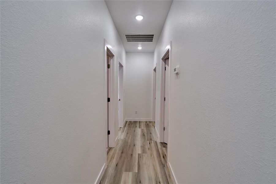Hallway featuring wood-finish flooring and recessed lighting