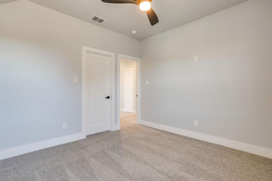 Empty room with carpet flooring and ceiling fan
