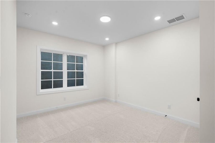 Empty room with carpet floors and recessed lighting