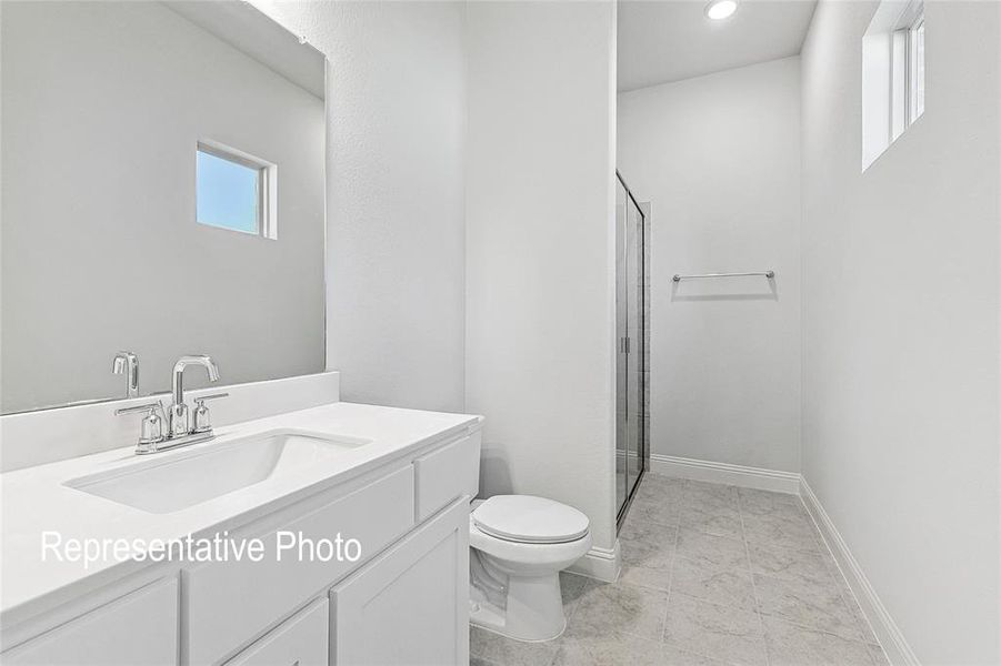 Bathroom with a shower with shower door, toilet, tile patterned flooring, and vanity