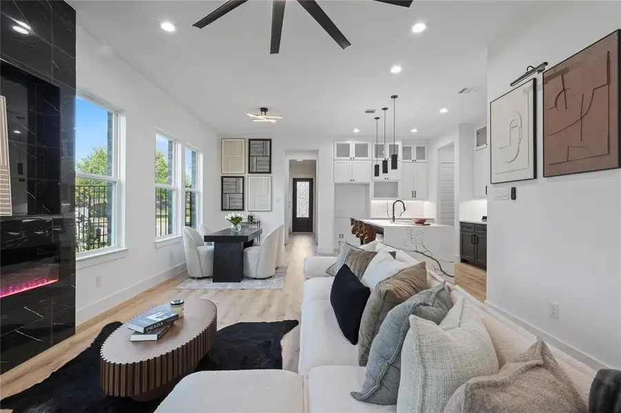 Living area with a ceiling fan, light wood-style floors, a barn door, and recessed lighting