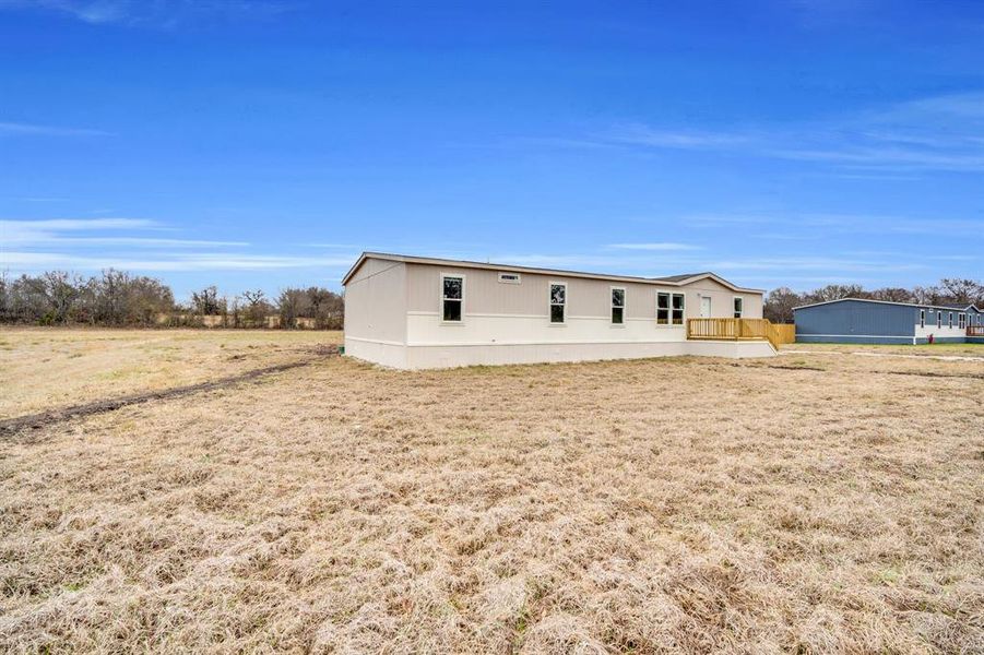Rear view of property with a yard and a wooden deck
