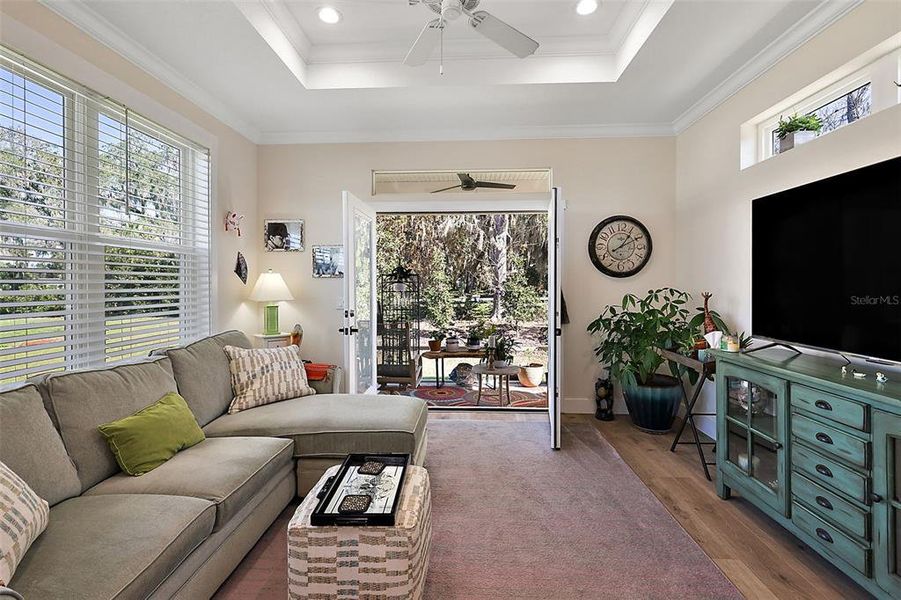 Spacious living room with French doors that open to screened porch.