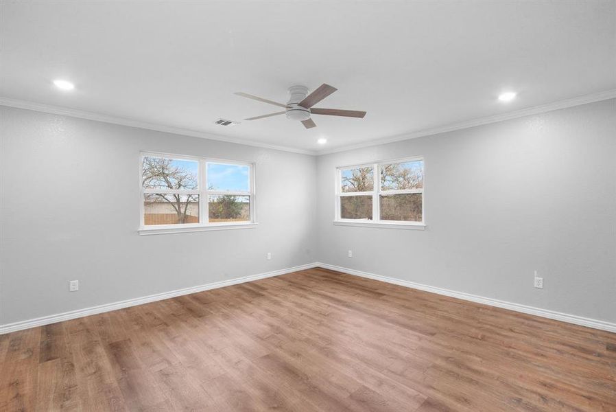 Unfurnished room featuring hardwood / wood-style floors, ceiling fan, and crown molding Unfurnished room featuring hardwood / wood-style floors, ceiling fan, and crown molding