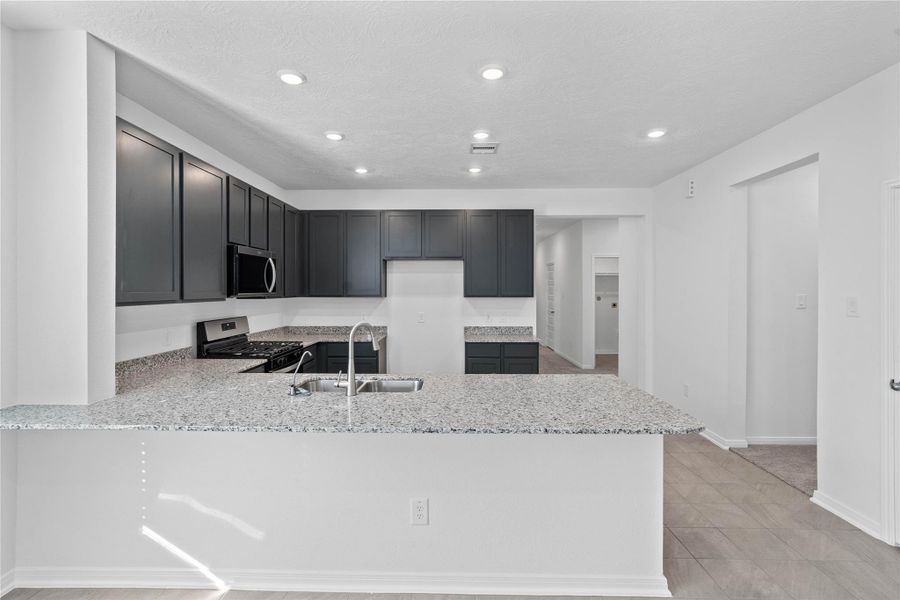 This spacious kitchen has it all—ample storage, generous counter space, and a layout that truly makes it the heart of the home.
