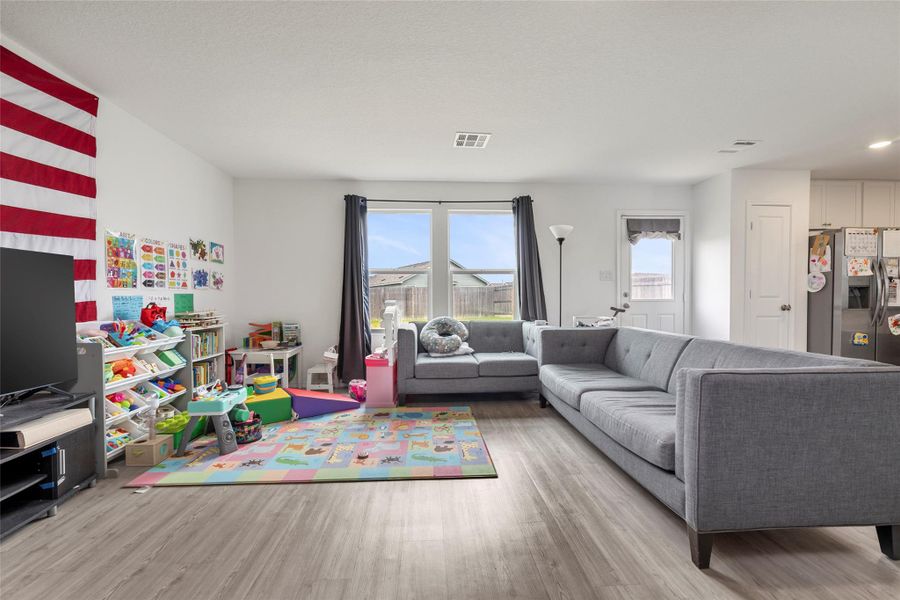 A well-lit family room with resilient flooring offers a versatile space for living and play.