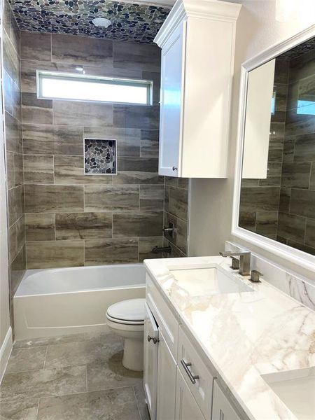 Full Bathroom featuring shower / bathing tub combination, marble counter-tops, plenty of natural light, and double vanity