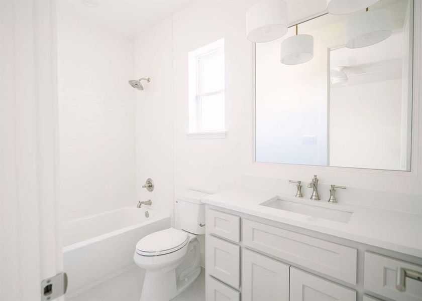 Full bathroom with vanity, toilet, and  shower combination