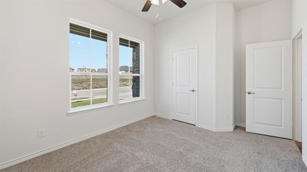 Unfurnished bedroom with light colored carpet and ceiling fan Unfurnished bedroom with light colored carpet and ceiling fan