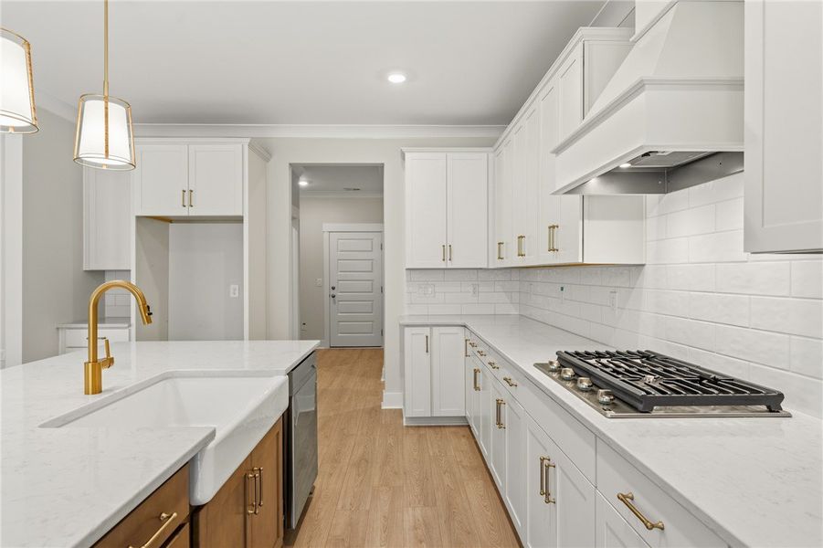 A pristine white kitchen features a large island w