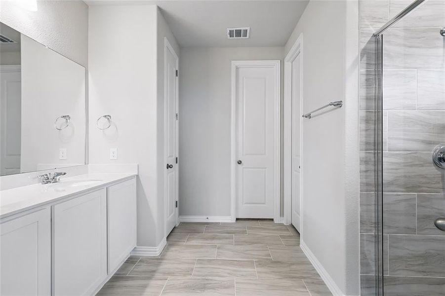 Bathroom featuring a stall shower and vanity