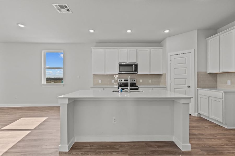 A kitchen with white cabinets.