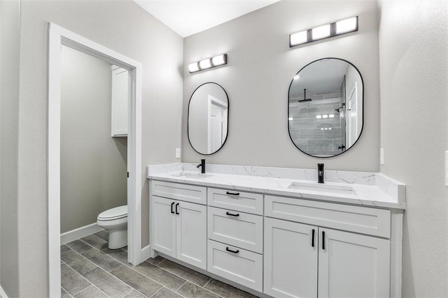 Bathroom featuring vanity, toilet, and walk in shower