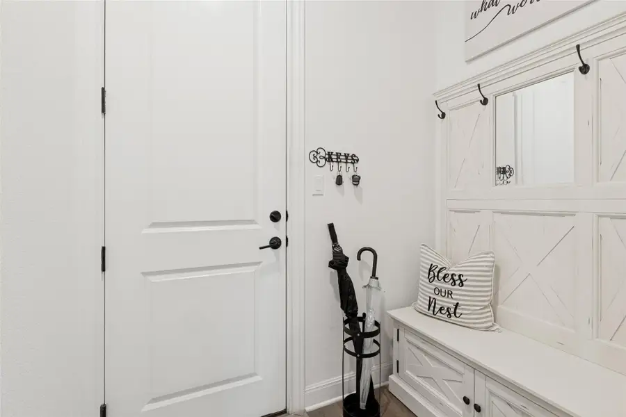 Crisp white wainscoting and a classic panel door define this welcoming entryway.