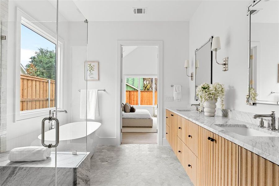Bathroom featuring double vanity, a soaking tub, ensuite bath, and a stall shower
