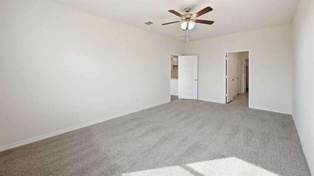 Spacious room featuring light gray carpet flooring, white painted walls, and a ceiling fan with integrated lighting Spacious room featuring light gray carpet flooring, white painted walls, and a ceiling fan with integrated lighting