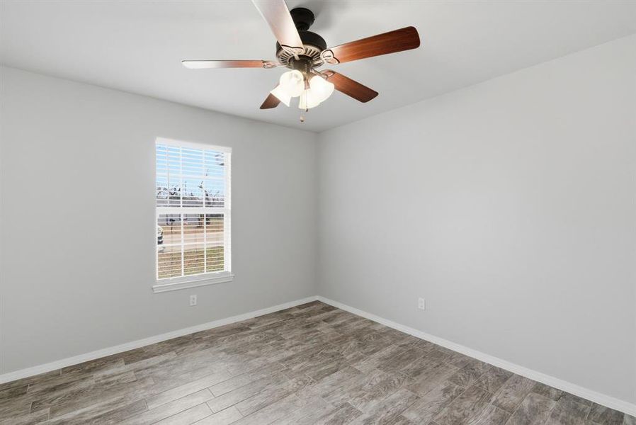 Empty room featuring wood finished floors and ceiling fan Empty room featuring wood finished floors and ceiling fan