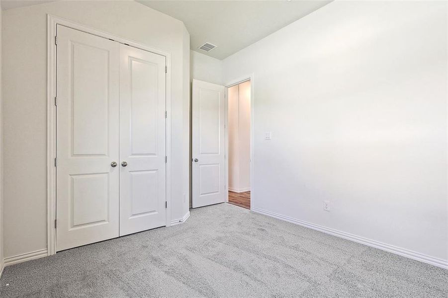 Unfurnished bedroom with a closet and light colored carpet