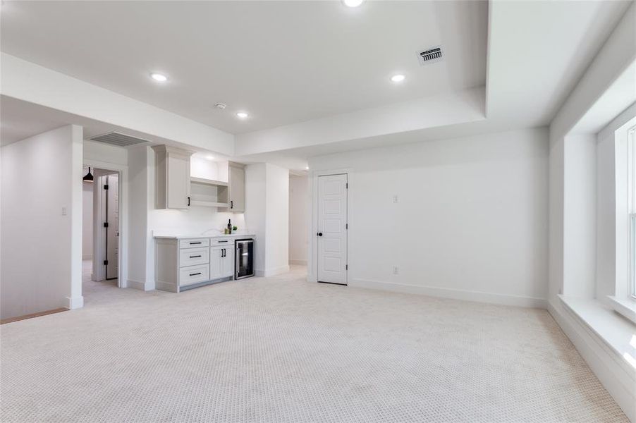 Bonus Area, designed carpet, white cabinets, recessed lighting, and beverage cooler